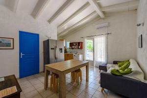 a living room with a table and a blue door at Résidence Itylon in Cargèse
