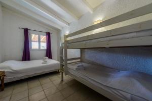 two bunk beds in a room with a window at Résidence Itylon in Cargèse +90 photos