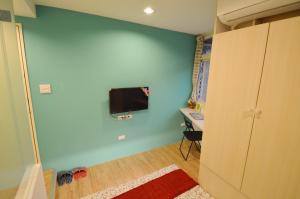台中的住宿－逢甲六六，一间设有蓝色墙壁的房间,里面配有电视