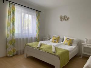 Habitación blanca con cama y ventana en Kincső Vendégház en Sárospatak