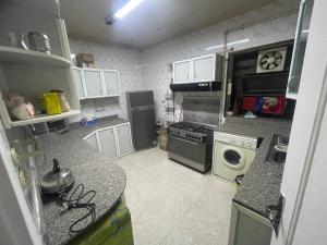a small kitchen with a stove and a refrigerator at Adam Abbas Al Akkad Hotel in Cairo