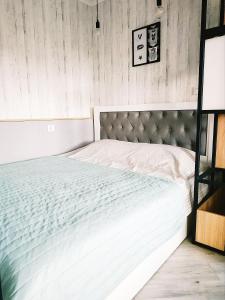 ein großes weißes Bett in einem Zimmer mit Holzwänden in der Unterkunft Затишні апартаменти в центрі Луцька in Luzk