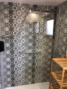 a bathroom with a black and white patterned wall at Apartamentos DELUXE Con Jacuzzi o Chimenea LOVE FOR TWO in Collado Mediano