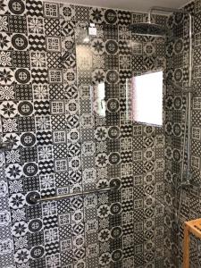 a bathroom with a black and white tile wall at Apartamentos DELUXE Con Jacuzzi o Chimenea LOVE FOR TWO in Collado Mediano +56 photos