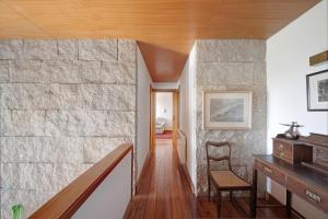 a staircase in a house with a stone wall at Villa do Bosque in Guilhabreu +21 photos