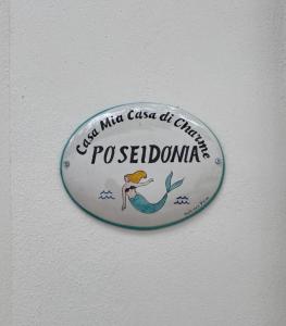 un cartel en una pared con un pájaro. en Casa Mia Casa di Charme en Santa Maria di Castellabate