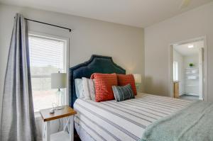 a bedroom with a bed with colorful pillows and a window at Utah Retreat - Hot Tub, Deck and Near National Parks in Escalante