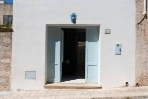 una porta per entrare in un edificio bianco con una porta di Gioiello a due passi dal CENTRO a Favignana