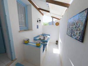 uma casa de banho com dois lavatórios e uma pintura na parede em Gioiello a due passi dal CENTRO em Favignana