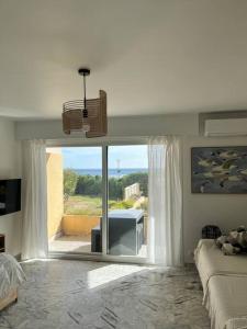 um quarto com uma grande porta de vidro deslizante com vista em Studio cosy avec terrasse sur la plage em La Seyne-sur-Mer