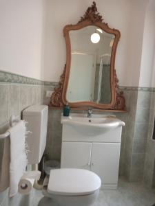 uma casa de banho com um WC, um lavatório e um espelho. em Holiday Home Carina em Dolceacqua