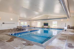 a large swimming pool with blue water in a building at Comfort Suites Burlington in Burlington