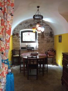 una sala da pranzo con tavolo, sedie e finestra di Holiday Home Carina a Dolceacqua