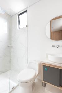 a white bathroom with a toilet and a sink at Apartamentos Weeki en Chapinero in Bogotá