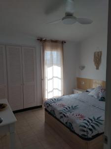 - une chambre avec un lit et une fenêtre dans l'établissement Apartamento con piscina y terraza en Ciutadella, Cala en Blanes, à Cala en Blanes