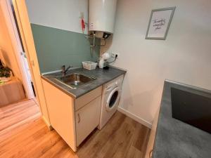 a kitchen with a sink and a washing machine at Apartamento en Santander in Santander