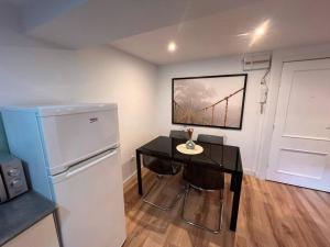 a kitchen with a black table and a refrigerator at Apartamento en Santander in Santander