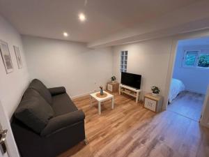 a living room with a couch and a flat screen tv at Apartamento en Santander in Santander