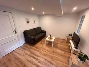 a living room with a black couch and a television at Apartamento en Santander in Santander