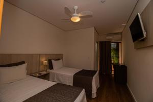 a hotel room with two beds and a ceiling fan at Prado Hotel in Amparo +31 photos