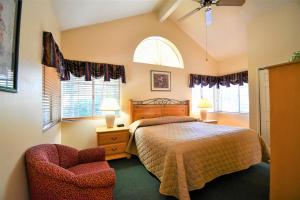 1 dormitorio con 1 cama, 1 silla y ventanas en North Bay At Lake Arrowhead en Lake Arrowhead