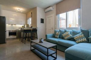 uma sala de estar com um sofá azul e uma cozinha em Konstantinos , luxury maisonette in Chania em Mourniaí