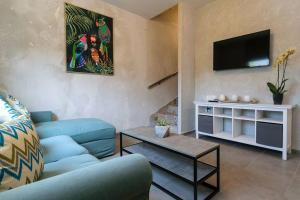 a living room with a blue couch and a tv at Konstantinos , luxury maisonette in Chania in Mourniaí
