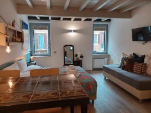 a living room with a table and a couch at Santa Marta Rooms&Studios in Verona