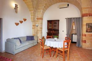 a living room with a table and a couch at Exedra Holiday House in Leverano