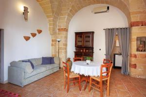 sala de estar con mesa y sofá en Exedra Holiday House, en Leverano