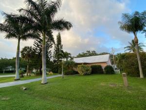 a house with palm trees in a yard at Vintage Vero Bungalow in Vero Beach