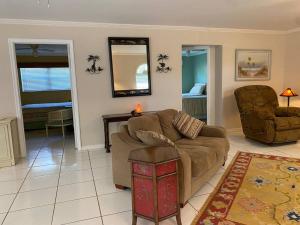 a living room with a couch and a chair at Vintage Vero Bungalow in Vero Beach