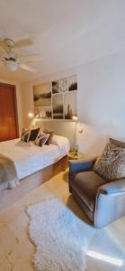 uma sala de estar com duas camas e um sofá em Oasis en la cala a pasos de mar!! em Cala de Finestrat