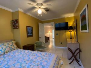 a bedroom with a bed and a flat screen tv at Vintage Vero Bungalow in Vero Beach
