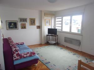 uma sala de estar com um sofá e uma televisão em Rooms Port em Dubrovnik