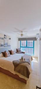 una camera con un grande letto e un ventilatore a soffitto di Oasis en la cala a pasos de mar!! a Cala de Finestrat