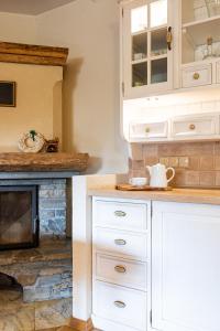 a kitchen with white cabinets and a fireplace at Willa Apart in Zakopane