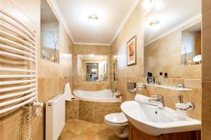 a bathroom with a sink and a toilet and a tub at Willa Apart in Zakopane