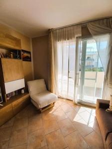 un soggiorno con sedia e una grande finestra di Casa Cocoon - holiday home a Brindisi