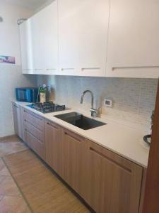 a kitchen with a sink and a counter top at Casa Cocoon - holiday home in Brindisi