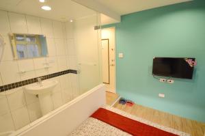 台中的住宿－逢甲六六，一间带水槽和淋浴的浴室以及一台电视。