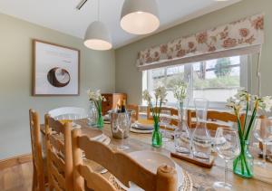a dining room with a table and chairs and a window at Higher Treliver Farmhouse in Saint Wenn