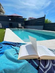 an open book laying on a blanket next to a swimming pool at Villa Fortuna in Podstrana