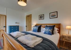 a bedroom with a large bed with towels on it at Higher Treliver Farmhouse Piggery in Saint Wenn