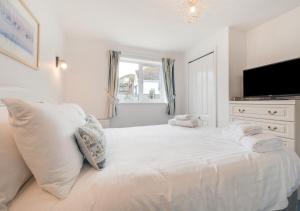 a white bedroom with a bed with towels on it at Loveday in Porthleven