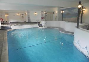a large pool with blue water in a hotel room at Finches in Gulval