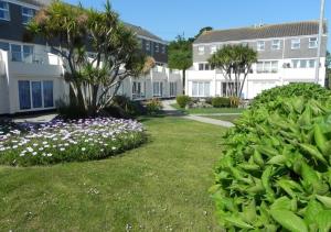 um quintal com flores e palmeiras e edifícios em Blue Horizon em St Ives