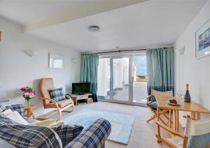 uma sala de estar com um sofá, cadeiras e uma mesa em Blue Horizon em St Ives