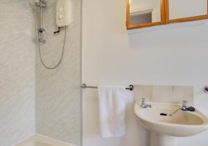 a white bathroom with a sink and a shower at 1 Copper Kettle Apartment in St Ives
