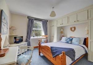 a bedroom with a bed and a desk and a table at Manor Cottage in Redruth
